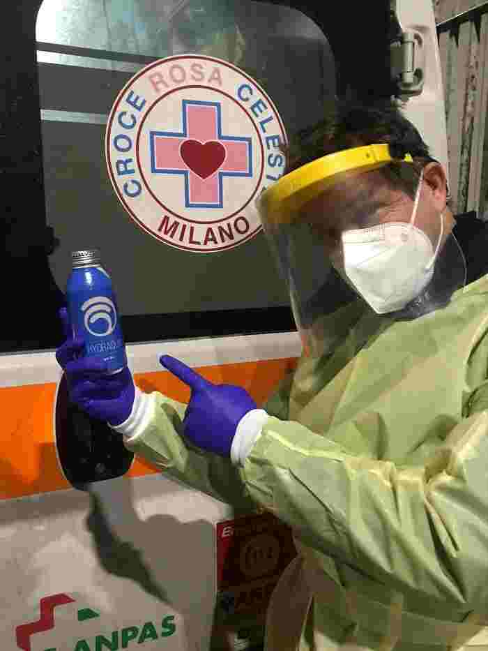 Volontario della Croce Rosa sorride mostrando HYDRAQUA