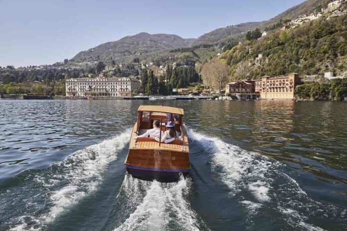 Driver and 2 guests on the boat – Villa d’Este on the background Driver and 2 guests on the boat – Villa d’Este on the background