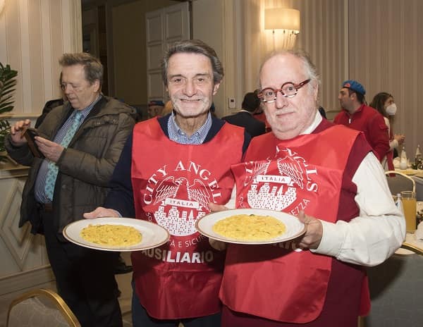 Attilio Fontana con Edoardo Raspelli mentre servono ai tavoli foto di Beatrice Piacentini a la Befana dei Clochard 2025