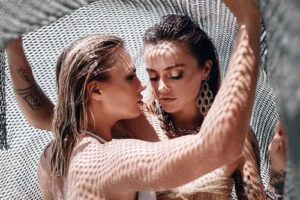two sexy mermaids caught fishing net beach posing portrait copia